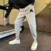 Moda masculina de otoño e invierno: pantalones de chándal clásicos, versátiles, de corte holgado y cómodos; pantalones cropped de estilo harén, modernos, elegantes y deportivos
