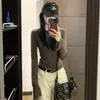 Camiseta de manga larga color verde militar estilo coreano para mujer, perfecta para principios de otoño como capa base, ofreciendo un look sofisticado y único con un corte ajustado.