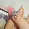 Anillo de Cobre con Cruz de Mariposa Hueca Simple de Línea Cruzada y Circonita Moda Anillo R7864