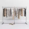 Estante de exhibición para tienda de ropa de pie de acero inoxidable plateado estante de exhibición minimalista estante isla para ropa de mujer perchero para ropa de niños