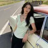 Camiseta negra de manga corta con cuello en V retorcido para mujer, nuevo estilo de verano 2026, hombros descubiertos únicos y hermosos, top ajustado extremadamente atractivo