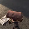 Bolsa pequena de camurça retrô para mulheres, nova bolsa de ombro casual outono/inverno 2026 com alça larga, bolsa crossbody cilíndrica tipo almofada