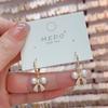 Pendientes elegantes de nicho con hebilla de oreja de perla y lazo, de moda coreana, elegantes y de diseño de celebridades de Internet, que combinan con todo.