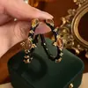Aretes de aro negros con patrón de cruz estilo court vintage, aretes empalmados estilo mediados de siglo, lujo ligero con un toque de alta gama, aretes elegantes para mujer