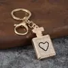 Llavero de botella de perfume con incrustaciones de diamantes, colgante de botella de perfume con pedrería en forma de corazón, accesorio de bolso de moda, regalo de llavero al por mayor