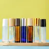 Botellas de perfume de vidrio al por mayor, botellas transparentes de rollerball, botellas de rollerball para masaje, botellas portátiles de aceites esenciales, botellas con tapa de veta de madera y bola de acero