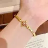 Novos acessórios de trevo de quatro folhas em esmalte com acabamento dourado da Xiaohongshu, com um toque retrô, luxuoso e de alta qualidade, exalando elegância