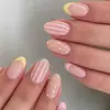 Uñas postizas de estilo francés a rayas y lunares color crema, largas en forma de almendra, tono piel con fondo rosa claro, con rayas verticales