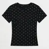 Camiseta blanca de manga corta con lunares estilo coreano para mujer, nueva colección verano 2026, con un elegante diseño en los hombros, un corte único y favorecedor.