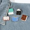 Broche de libro de venta caliente transfronterizo europeo y americano Insignia de metal con letra de libro creativa de dibujos animados Accesorios de decoración para mochila de estudiante