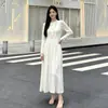 La nueva colección de otoño de Miyake: un vestido largo ajustado y plisado con cuello redondo y mangas largas, con un diseño de estilo coreano y una tela segmentada, texturizada y plisada en color blanco roto