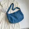 A bolsa popular de jeans lavado deste ano é uma bolsa transversal de grande capacidade, adequada para estudantes usarem na aula, apresentando um design de lona estilo japonês e uma versão simples coreana