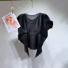 Venda direta da fábrica: Top feminino Miyake de manga curta com gola redonda, design de barra irregular, estilo curto plissado, camiseta versátil