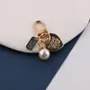 Nova fivela de porta criativa com chaveiro de liga de pérola em formato de coração vazado, pingente para capa de fone de ouvido e bolsa DIY, joias