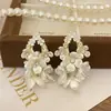 Pendientes de perla de flor blanca explosiva temperamento de alta gama lujo ligero nuevos pendientes de pétalo pendientes delicados venta al por mayor