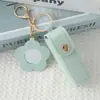 Mini llavero de lipstick portátil, bolsa redonda de cuero con espejo de maquillaje, accesorio para niñas, colgante de bolsa de espejo de maquillaje portátil