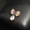 Broche Elegante e Único Exquisito em Forma de Laço com Zircônias Verdes e Roxas Incrustadas com Strass, Broche Pin de Gola Dourado Anti-Exposição para Mulheres