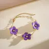 Conjunto de dos piezas: Collar de metal estilo dulce europeo y americano con flor de goteo de aceite, pendientes de nicho transfronterizos de alta gama, pulsera linda y única