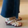 Primer encuentro con las únicas sandalias romanas de tacón de cuña, punta cuadrada retro, tejido y tiras cruzadas, destalonadas.
