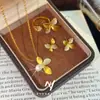 Set de Lirio Dorado Arena Estilo de Lujo Ligero Gama Alta Collar Anillo Pendientes Flor de Cuatro Hojas Punto de Hada Diamante para Mujer Venta al por Mayor