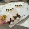 2023 nuevos aretes de perlas de temperamento de alta gama de lujo ligero aretes al por mayor aretes de lazo negro para mujer