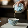 Juego de té de cerámica pintado a mano bajo vidriado azul con motivos de peces y lotos, que incluye un gaiwan, tetera, taza de maestro, taza de té, taza de degustación, quemador de incienso y soporte para tetera