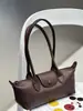 Piel de vaca de capa superior estilo francés 2026 primavera-verano nuevo bolso baguette, bolso tipo dumpling, bolso de mano para el trabajo, bolso de hombro, bolso cruzado, bolso de axila
