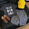 Roupa Infantil Coreana 2026 Verão Novidades Conjunto de Duas Peças Tricô Xadrez de Manga Curta para Meninos Academia Tendência