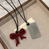 Collar con Lazo Rojo Ankora para Mujer Diseño de Nicho Cadena para Suéter Acero de Titanio de Alta Gama Peine Collar de Cuerda Larga Negra