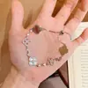 Pulsera popular de Xiaohongshu con incrustaciones de microdiamantes, diseño hueco de trébol de cuatro hojas para mujer, moderna y versátil con un toque de alta gama, pulsera ajustable