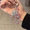 Corrente de celular laço deslumbrante estilo coreano, pingente de pulso rosa com pérolas de luxo leve para Instagram, acessório requintado para bolsa e chave