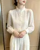 Elegante camisa de cuello alto estilo francés para la primavera 2026, blusa blanca única y nueva de manga larga estilo corte.