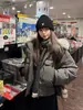 Chaqueta de algodón versátil estilo coreano 2026 nueva para mujer, con capucha ribeteada de pelo, en color gris gaviota, corte holgado y diseñada para abrigar en invierno.