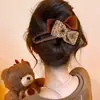 Um grampo de cabelo estiloso e versátil para mulheres, apresentando um design de bico de pato que não pressiona a parte de trás da cabeça, perfeito para criar penteados elegantes no outono e inverno.
