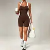 Nuevo conjunto de yoga de una pieza transfronterizo para mujer, con colores contrastantes, diseño de espalda cruzada, shorts tipo culotte color durazno y ropa deportiva integrada.
