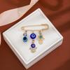 Broche de borla de ojo de diablo con incrustaciones de diamantes, estilo creativo europeo y americano, con sentido avanzado, ojos azules, suéter de cintura ajustada, broche de viento frío