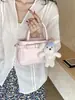 Bolsa Feminina Transfronteiriça 2026 Nova Tendência Estilo Coreano Bolsa de Mão Transversal Versátil Cinto de Couro Decoração Pingente de Pelúcia Bolsa Quadrada Pequena de Ombro Único