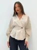 Camisa sencilla de mujer con cuello en V cruzado, manga larga, detalles metálicos y fruncido en la cintura, elegante y adecuada para el uso diario en el transporte europeo y americano.