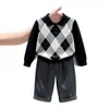 Ropa infantil coreana 2026 colección de otoño nueva: suéter clásico negro con patrón de rombos y cuello, y pantalón de traje gris recto para niños