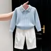 Roupas infantis coreanas coleção outono/inverno 2026: suéter de tricô azul com gola polo vazada e calça branca casual de corte reto