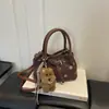 Nuevo bolso cubo de lunares para mujer de principios de otoño 2026, bolso de mano de nicho de lujo ligero de alta gama, bolso cruzado para ir al trabajo, bolsos de mujer al por mayor
