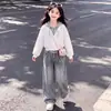 Conjunto de moda para principios de otoño para niñas: un elegante conjunto de dos piezas que presenta un top con capucha y bloques de color y unos pantalones vaqueros de diseño único