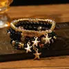 Pulseras multicapa al por mayor, juego de cuatro piezas de joyería con cuentas de artesanía en vidrio, juego de pulseras elásticas, accesorio de mano con soporte de flor de hierro