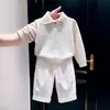 Conjunto de dos piezas para niño estilo coreano otoño e invierno 2026: suéter de punto beige con cuello, elegante, y pantalones blancos de pierna ancha para niños