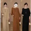 Conjunto feminino de outono da moda: um top de tricô de caimento solto e modelador com mangas morcego combinado com uma saia midi plissada - um conjunto estiloso de duas peças