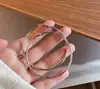 Pendientes de anillo liso transfronterizos europeos y americanos con aguja de plata, pendientes de nicho de viento frío, pendientes de temperamento de moda, lujo ligero, sentido de alta gama