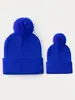 Comercio exterior artículo de venta caliente gorro de punto de color liso con pompón otoño e invierno cálido a prueba de viento gorro de lana rizada para hombre y mujer protección para los oídos al aire libre