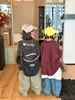 Nueva camisa elegante y genial de manga larga para niños primavera/otoño 2026 chaqueta holgada estampada a cuadros versión coreana camisa con letras