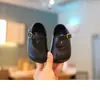 Zapatos para bebé estilo coreano con diseño de puntera dividida sintética, con una simple hebilla metálica, suela suave y diseño transpirable y moderno para bebés y niños pequeños.