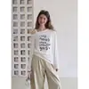 Blusa casual de manga longa, soltinha e com ombros à mostra, novo estilo quente de inverno com design francês e camiseta estampada 0681